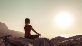 黄昏落日美女高山瑜伽打坐冥想摄影图片